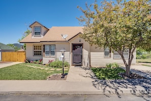 Cozy home with a front door, surrounded by a well-manicured lawn and a small tree.