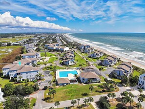 Uma área residencial costeira com casas, piscina e praia.