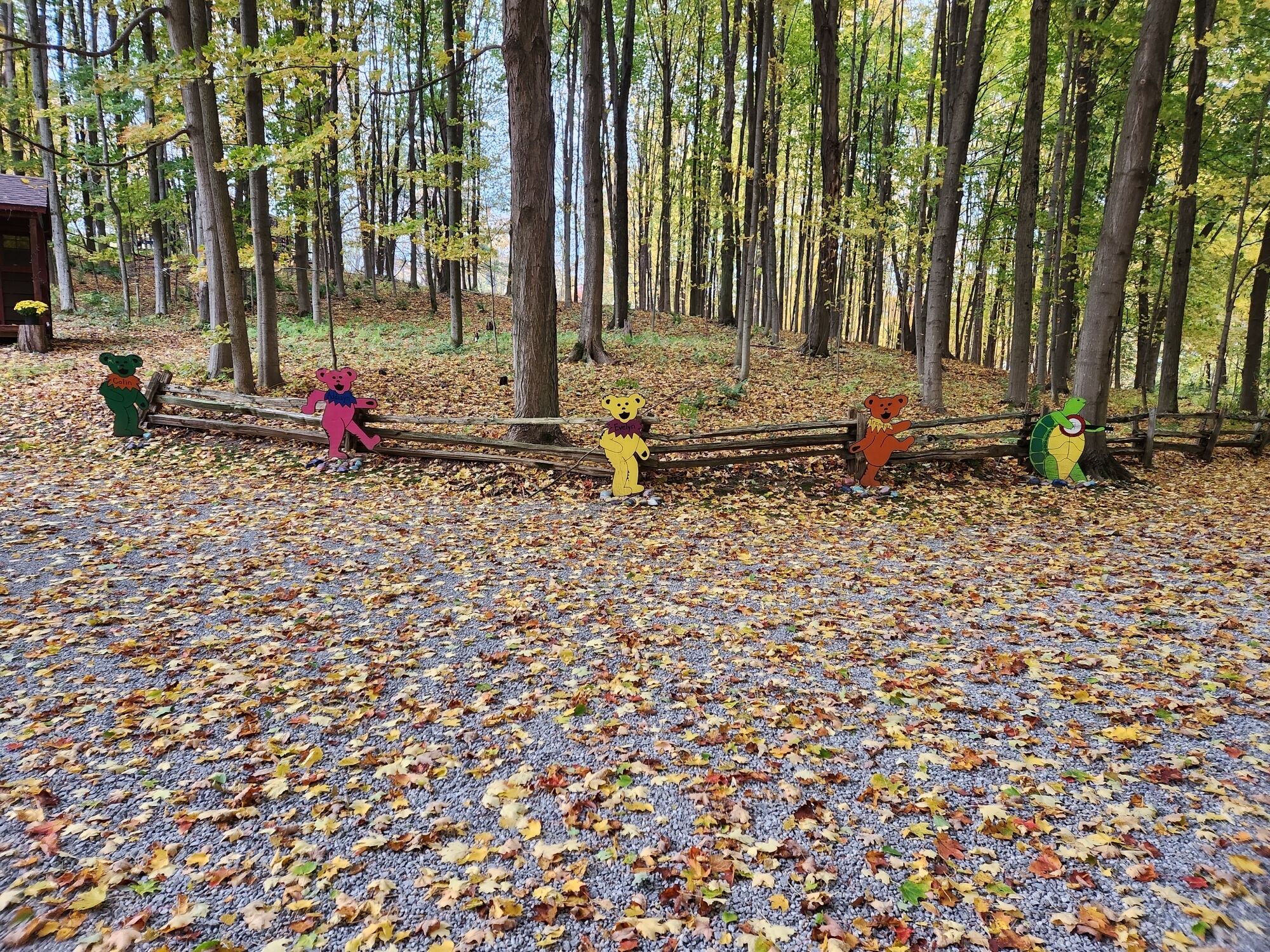 Une scène de forêt avec une clôture en bois et des décorations représentant des ours aux couleurs vives.
