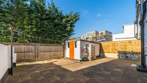 A backyard with a small shed, a wooden fence, and a bicycle.