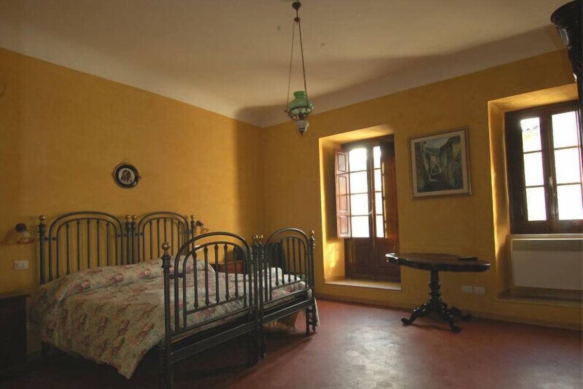 A room with a bed, a small table, and a window.