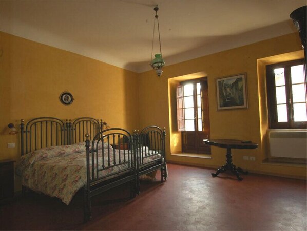 A room with a bed, a small table, and a window.