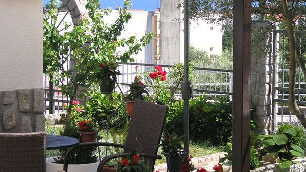 A patio with outdoor furniture, potted plants, and a view of the sea. - Apartments Oribella (Krk)