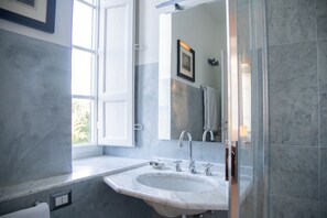 Un baño con un ventanal grande, un lavabo y un espejo.