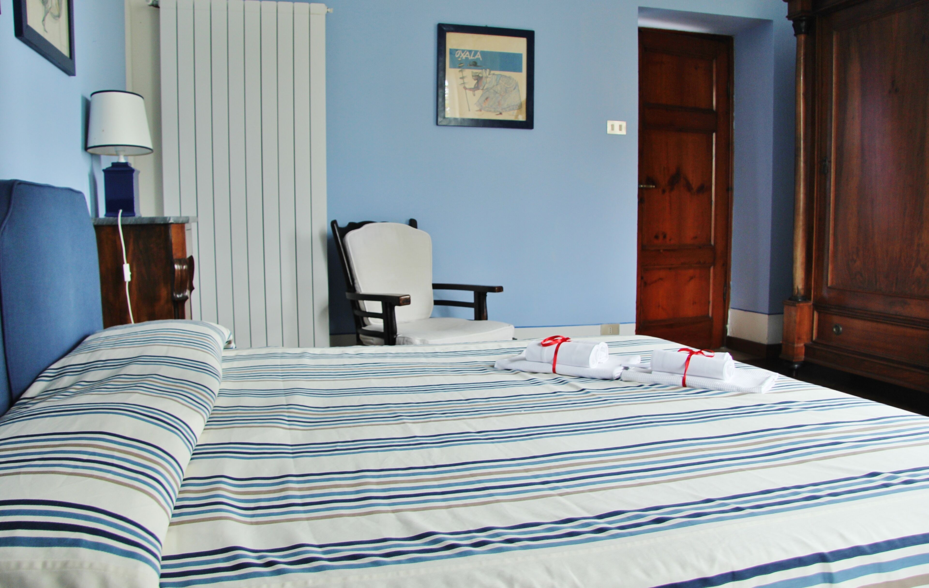Ein Hotelzimmer mit Bett, Stuhl, Schreibtisch und Kleiderschrank.