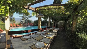 An outdoor dining area with a pool and a view of the mountains. - Agriturismo Villa Pedone (Lucca)