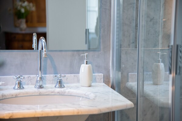 A bathroom with a marble sink, three faucets, and a soap dispenser. - Agriturismo Villa Pedone (Lucca)