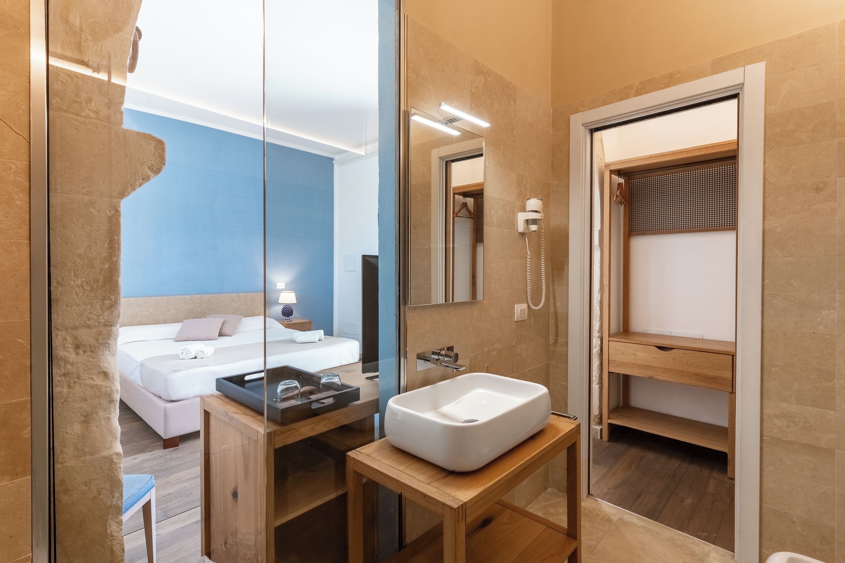 A modern bathroom with a large mirror, a white sink, and a shower area.