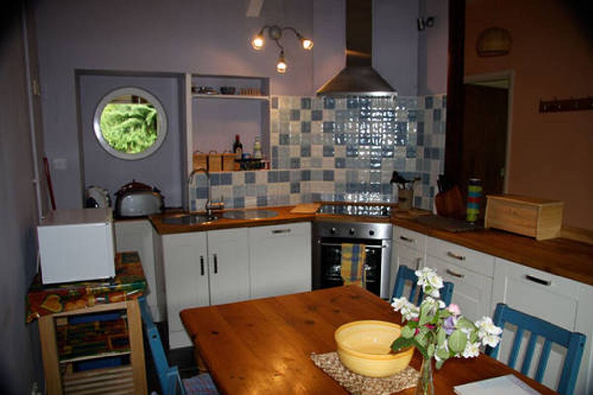 A kitchen with white cabinets, a wooden table, and a window.