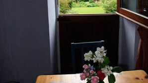 Ett rum med ett fönster som vetter ut mot en trädgård.