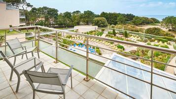 Un balcon donnant sur une piscine et un jardin.