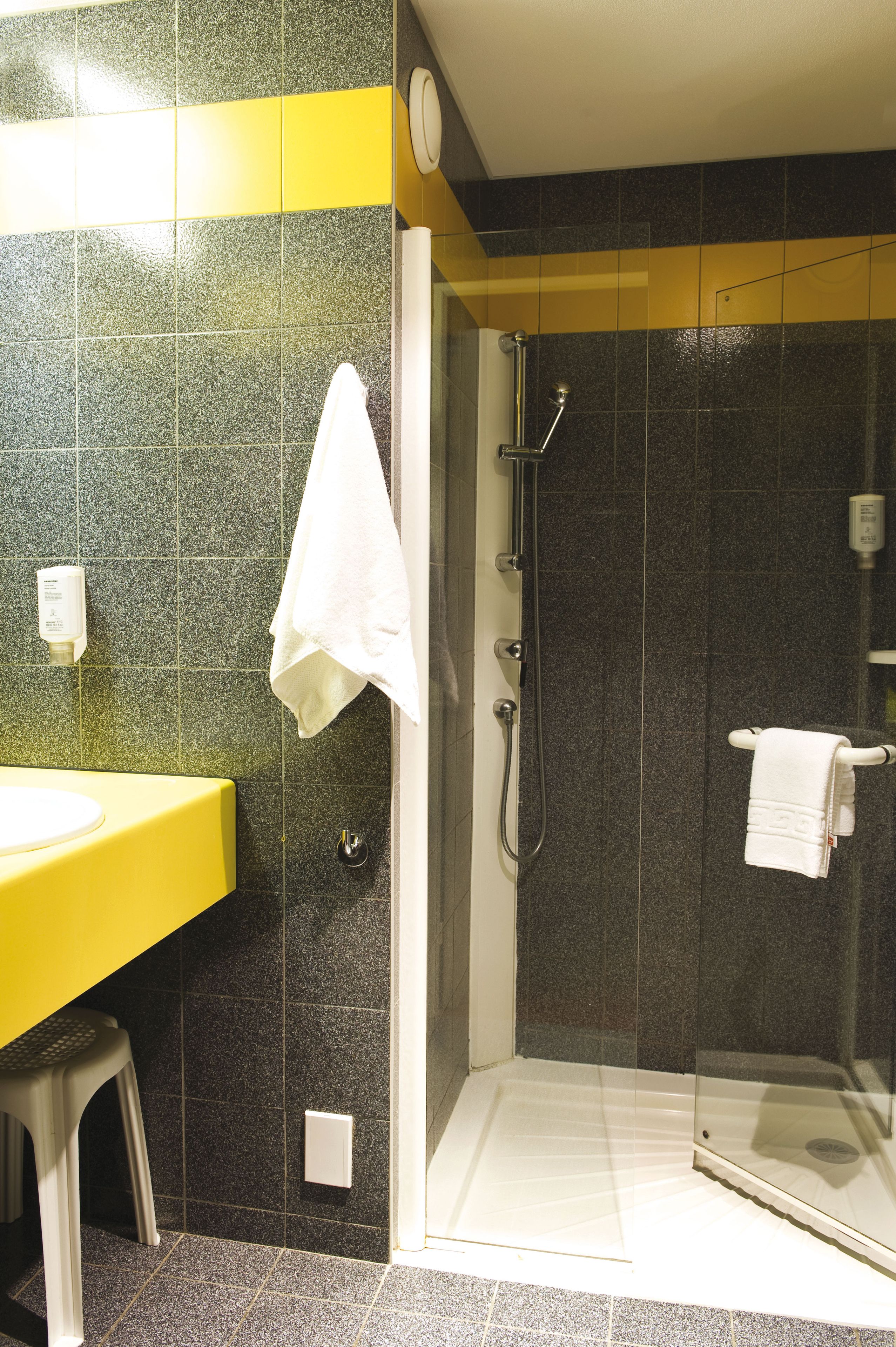 A bathroom with a shower, a sink, and a toilet.