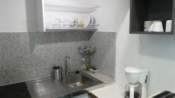 Une cuisine dotée d’un plan de travail en granit, d’un évier en acier inoxydable, d’une machine à café et d’un grille-pain.