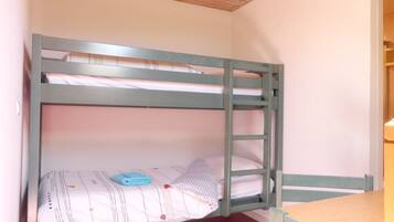 A bunk bed with a ladder, a small table, and a red carpeted floor.