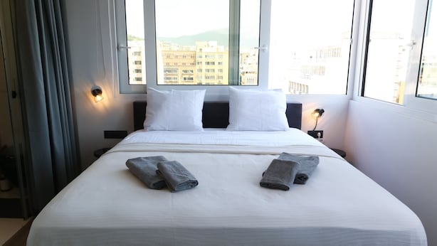 A hotel room with a large bed, two pillows, and two towels. - Triple A - Evripidou 36 (Athens)