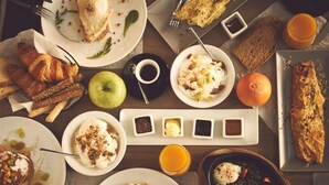 A breakfast buffet with various dishes, including pastries, fruits, and condiments. - Triple A - Evripidou 36 (Athens)
