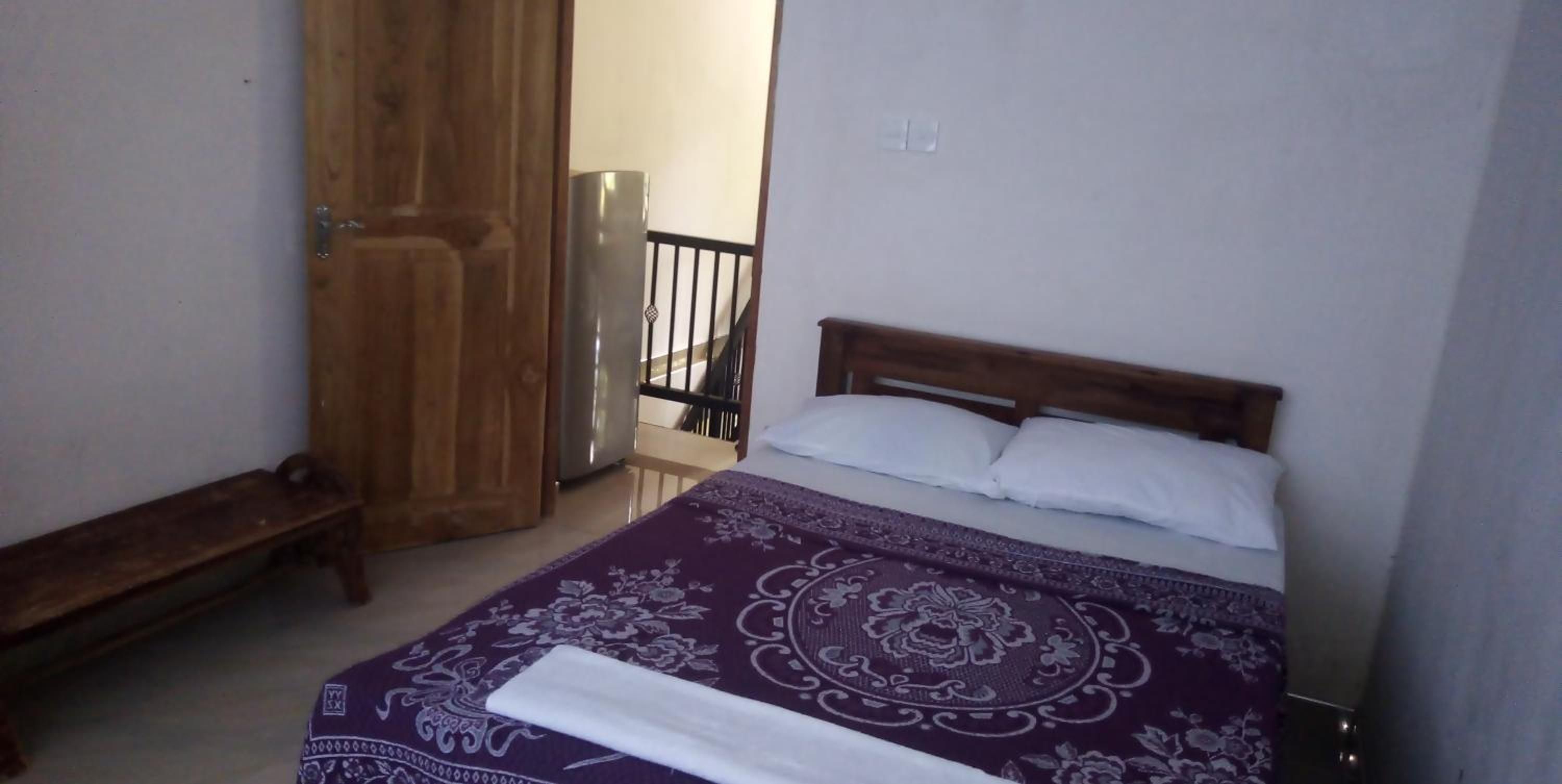 Una camera da letto con un letto, una panca in legno e un armadio.