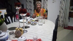 A dining table with plates, glasses, and a clock. - Senuri Home stay (Polonnaruwa)