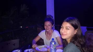 Un comedor con mesas y sillas, una botella de agua y platos de comida.
