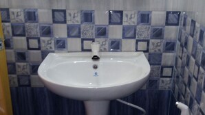 A bathroom with a white sink, toilet, and a mirror above the sink. - Senuri Home stay (Polonnaruwa)