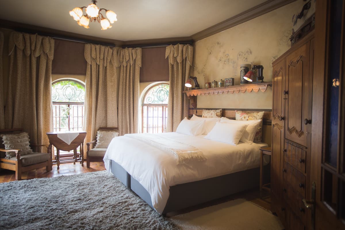 Une chambre à coucher avec un grand lit, des meubles en bois et un lustre.