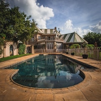 Una piscina al aire libre, sillones reclinables de piscina