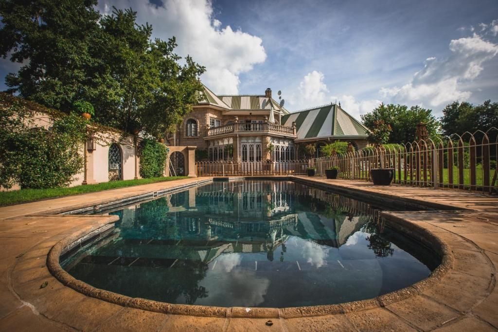 A large, ornate building with a swimming pool in front.