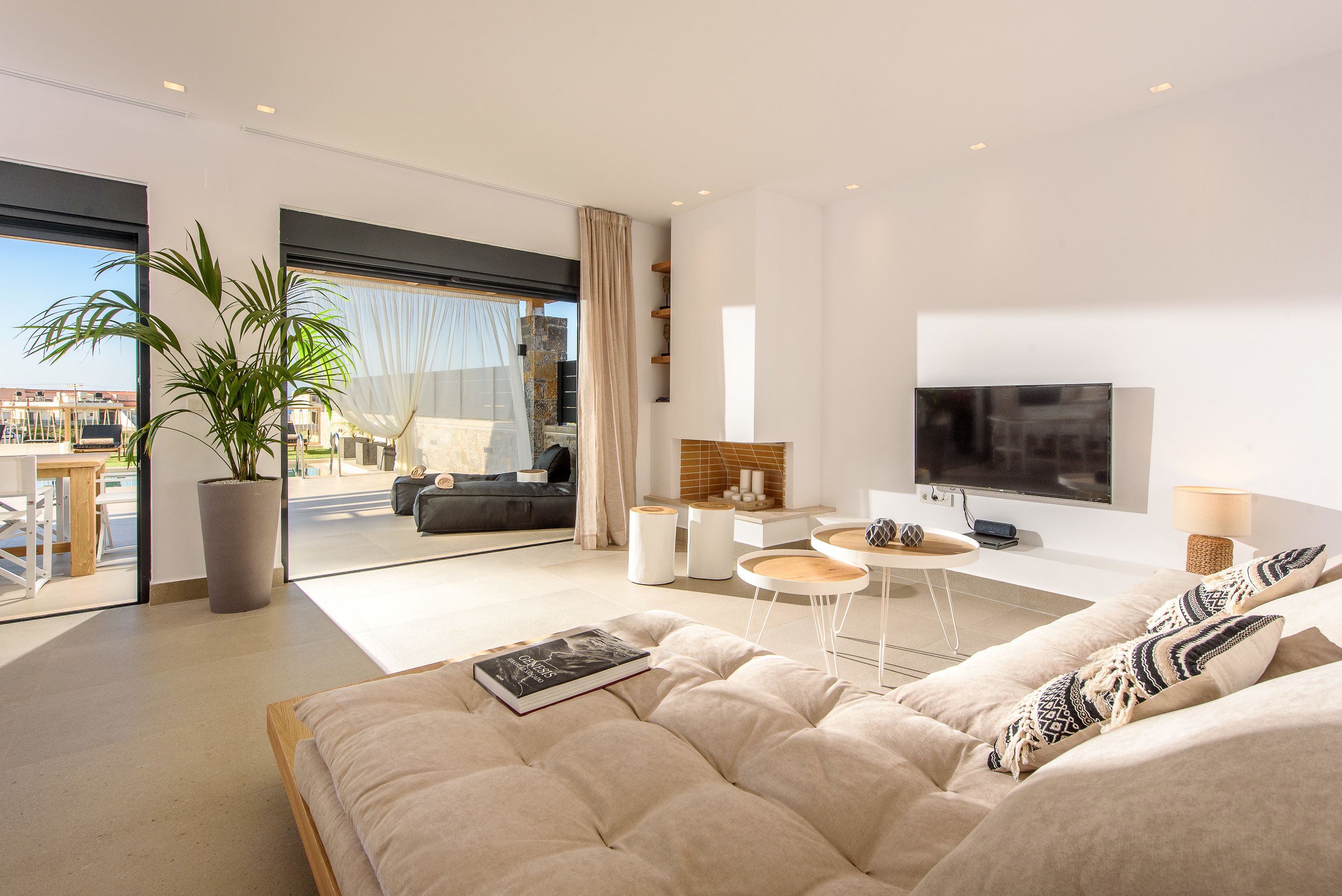 Un salon moderne avec un grand lit, une télévision et un balcon offrant une vue sur la ville.