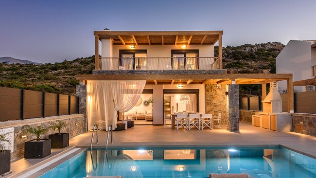 A two-story house with a pool, outdoor seating, and a view of the hills. - Villa Calma (Agios Nikolaos)