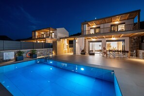 Una piscina al aire libre, sombrillas, tumbonas