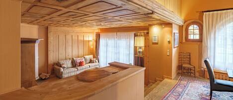 A wooden interior with a sofa, a wooden bench, and a rug.
