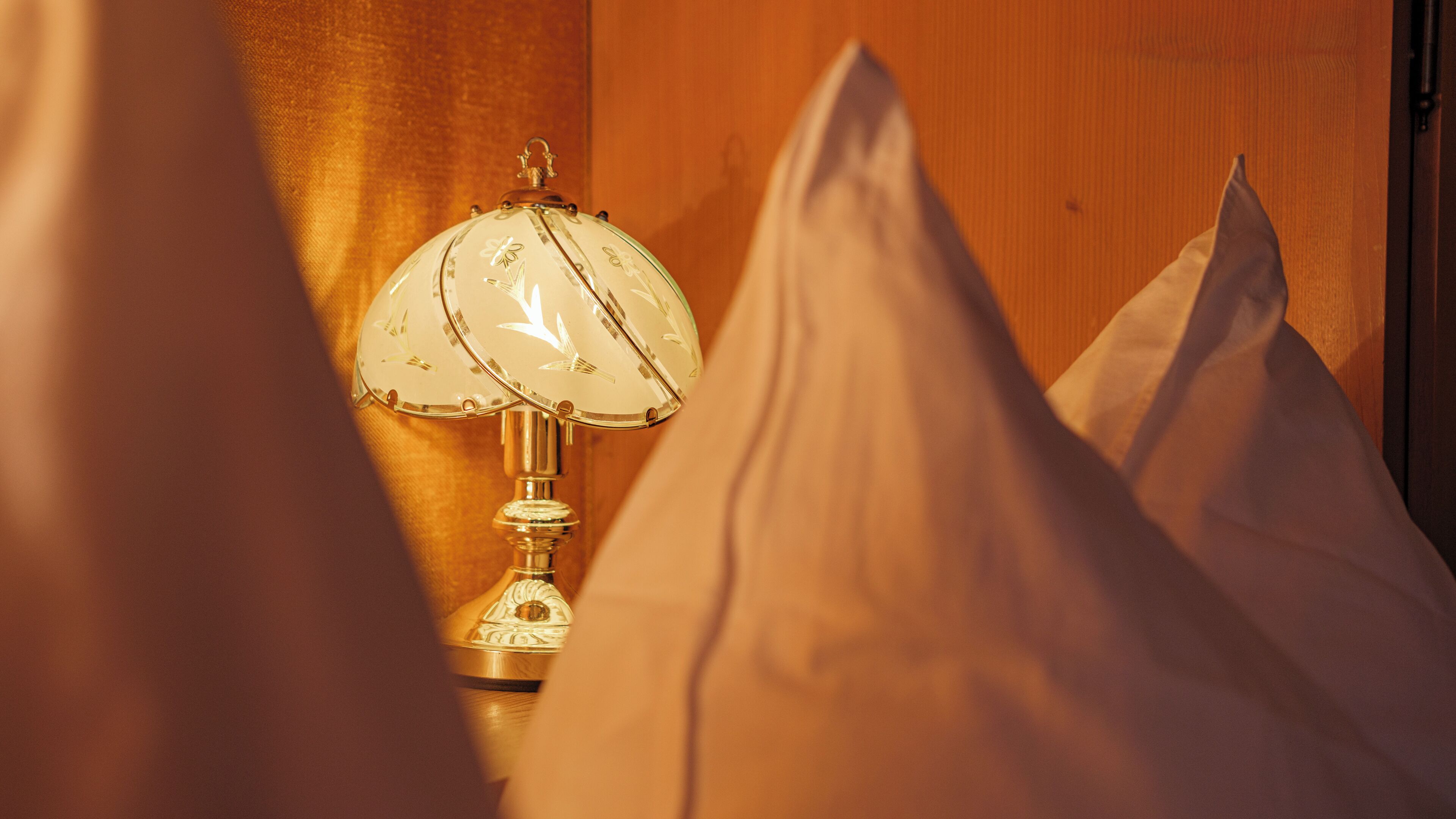 A lamp with a floral design on a wooden surface.