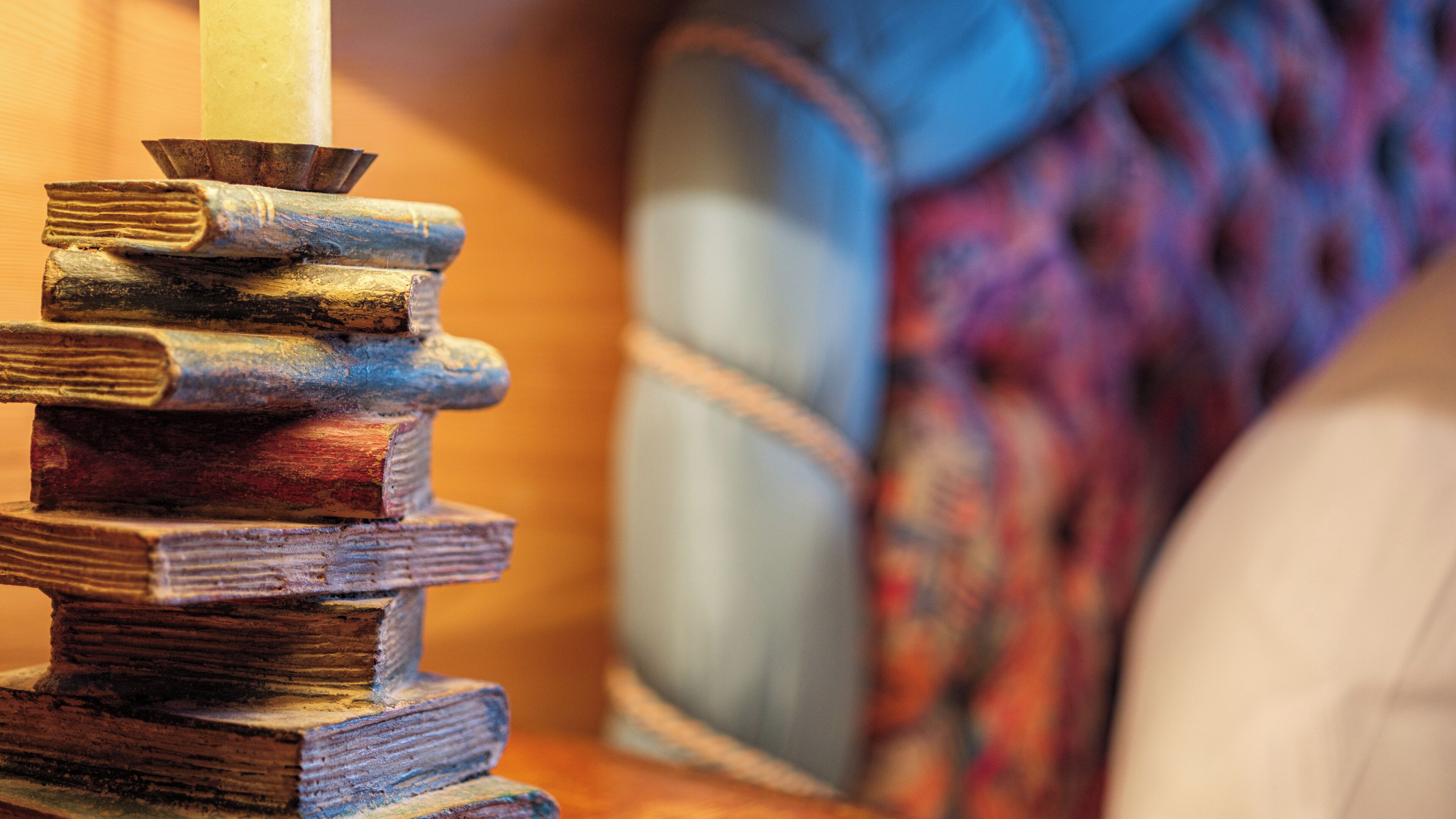 A stack of old books with a candle in the center.