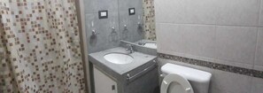 A bathroom with a sink, mirror, and toilet. - Departamentos MTD (Balcarce)