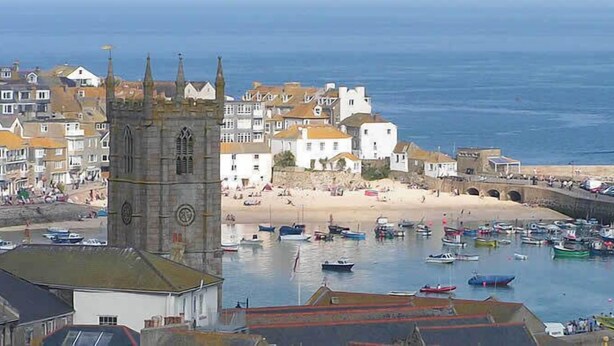 Une ville côtière qui se distingue par son église imposante, sa plage de sable et son port de plaisance où sont amarrés des bateaux.
