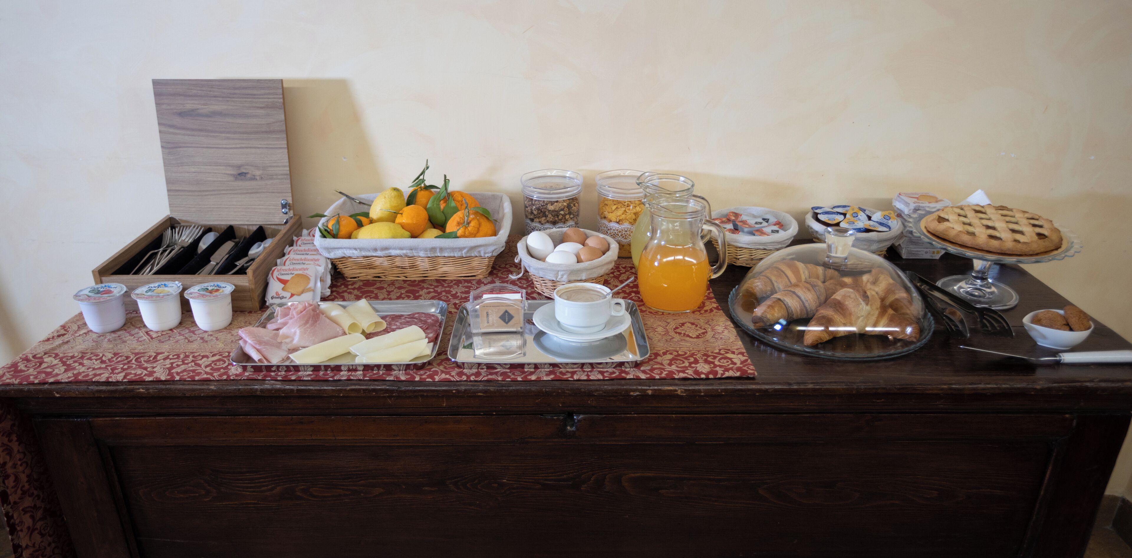 A breakfast buffet with various food items, including fruits, pastries, and beverages.