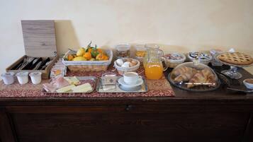 A breakfast buffet with various food items, including fruits, pastries, and beverages.