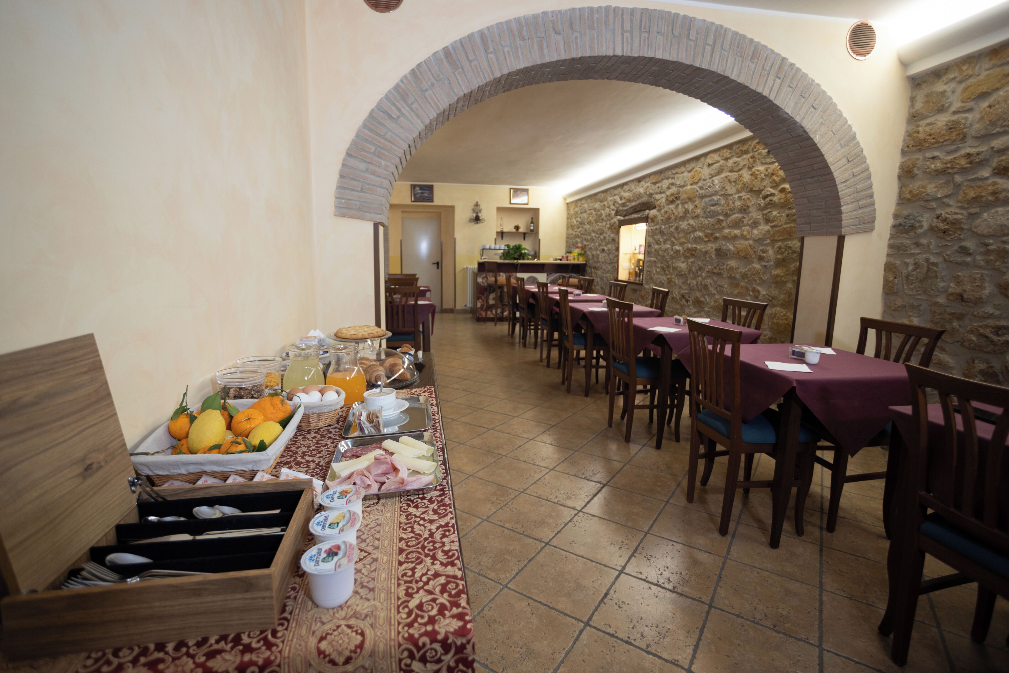 A dining area with a long table, chairs, and a buffet setup.