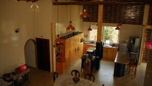 A spacious kitchen with wooden cabinets, a dining table, and a refrigerator.