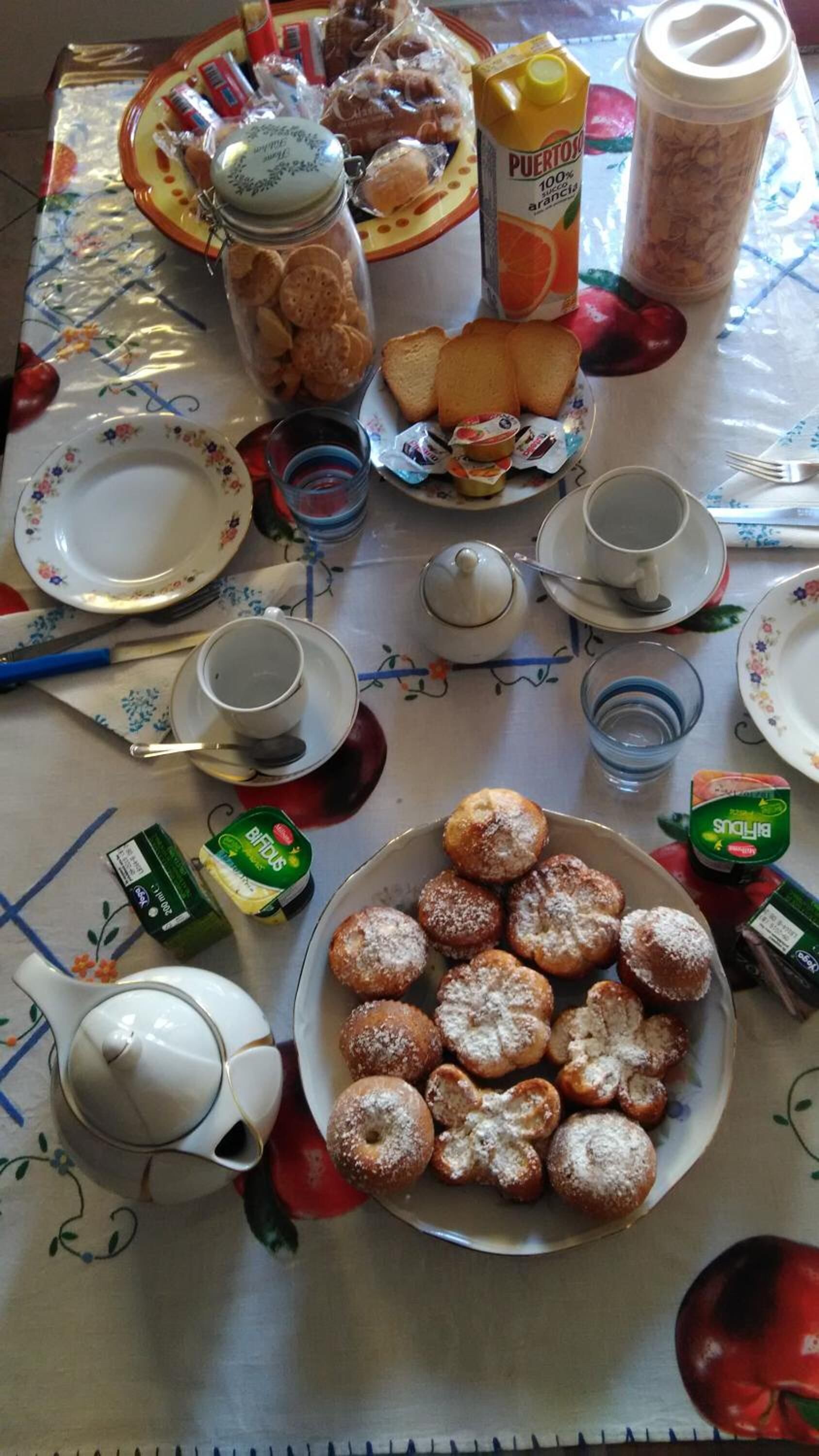 A breakfast table with pastries, juice, and condiments.