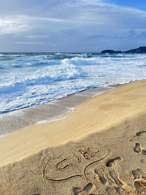 A sandy beach with footprints and a wave crashing onto the shore. - Bed and Breakfast L'Abete (Guspini)