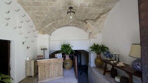 Ein rustikales Interieur mit Steindecke, einer Holztresen und Topfpflanzen.