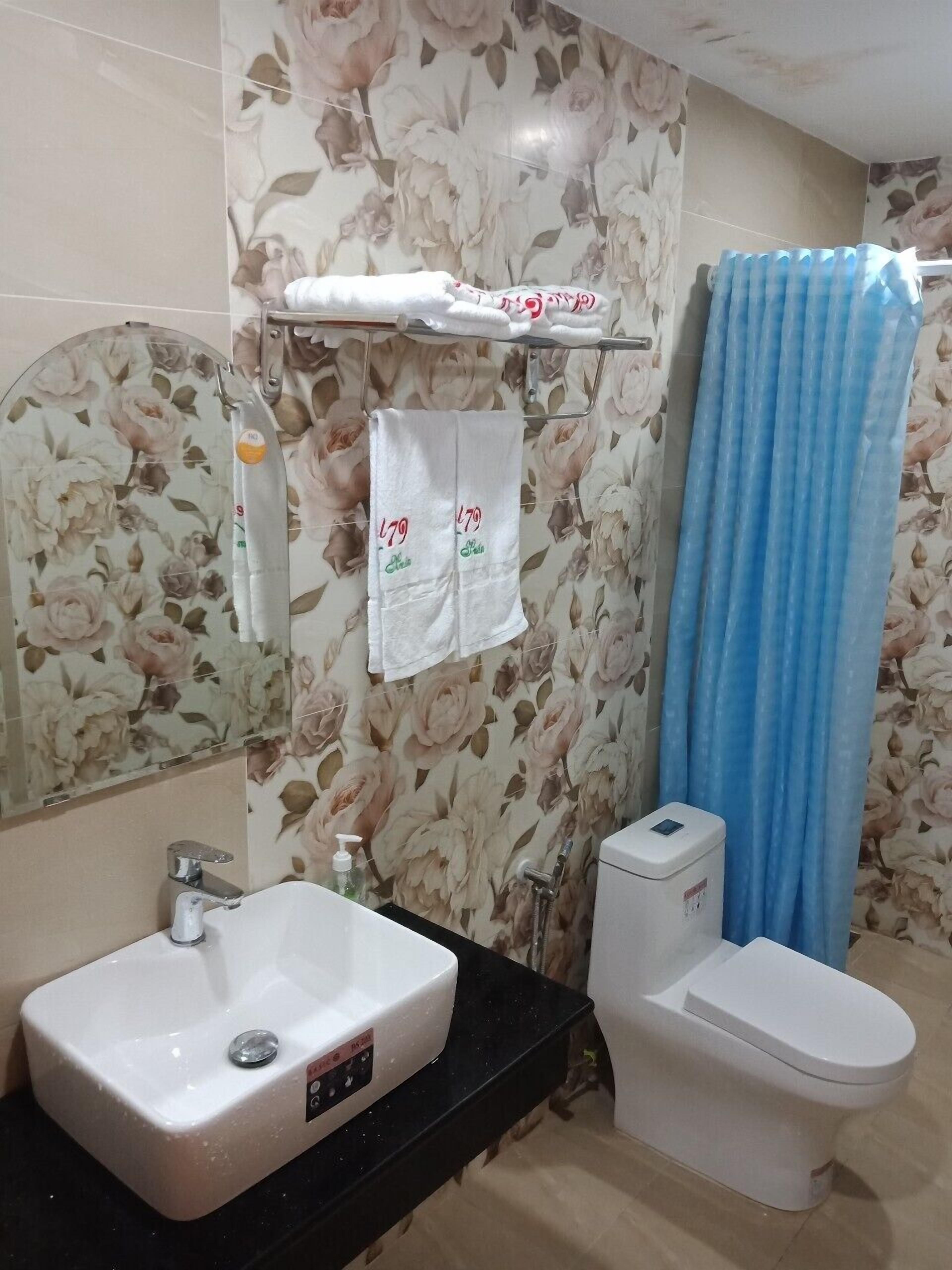 A bathroom with a sink, toilet, and shower curtain.