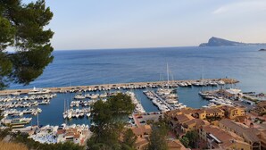 Un puerto deportivo con numerosas embarcaciones amarradas, rodeado de edificios de arquitectura mediterránea.