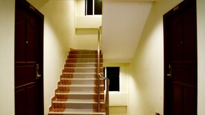 A staircase with wooden steps and metal railings, leading to an upper floor. - BB Residence (Pattaya)