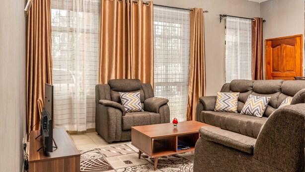 Una sala de estar con un sofá, un sillón y una mesa de centro.