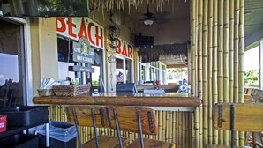 A beach bar with wooden chairs and a bamboo wall. - Steps Away from the Soft, White, Sandy Beaches of Beautiful Marco Island!! (Marco Island)