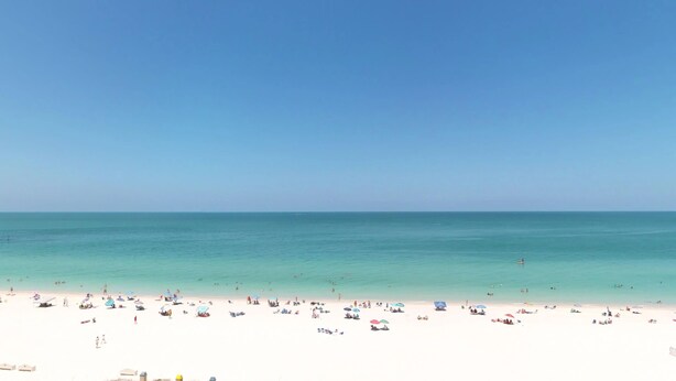 A beach with clear turquoise water and a sandy shore. - Steps Away from the Soft, White, Sandy Beaches of Beautiful Marco Island!! (Marco Island)