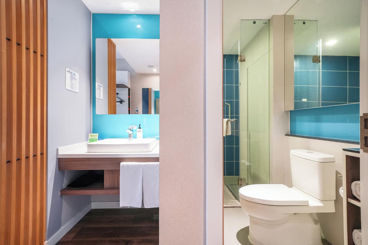 A modern bathroom with a shower, toilet, and sink.