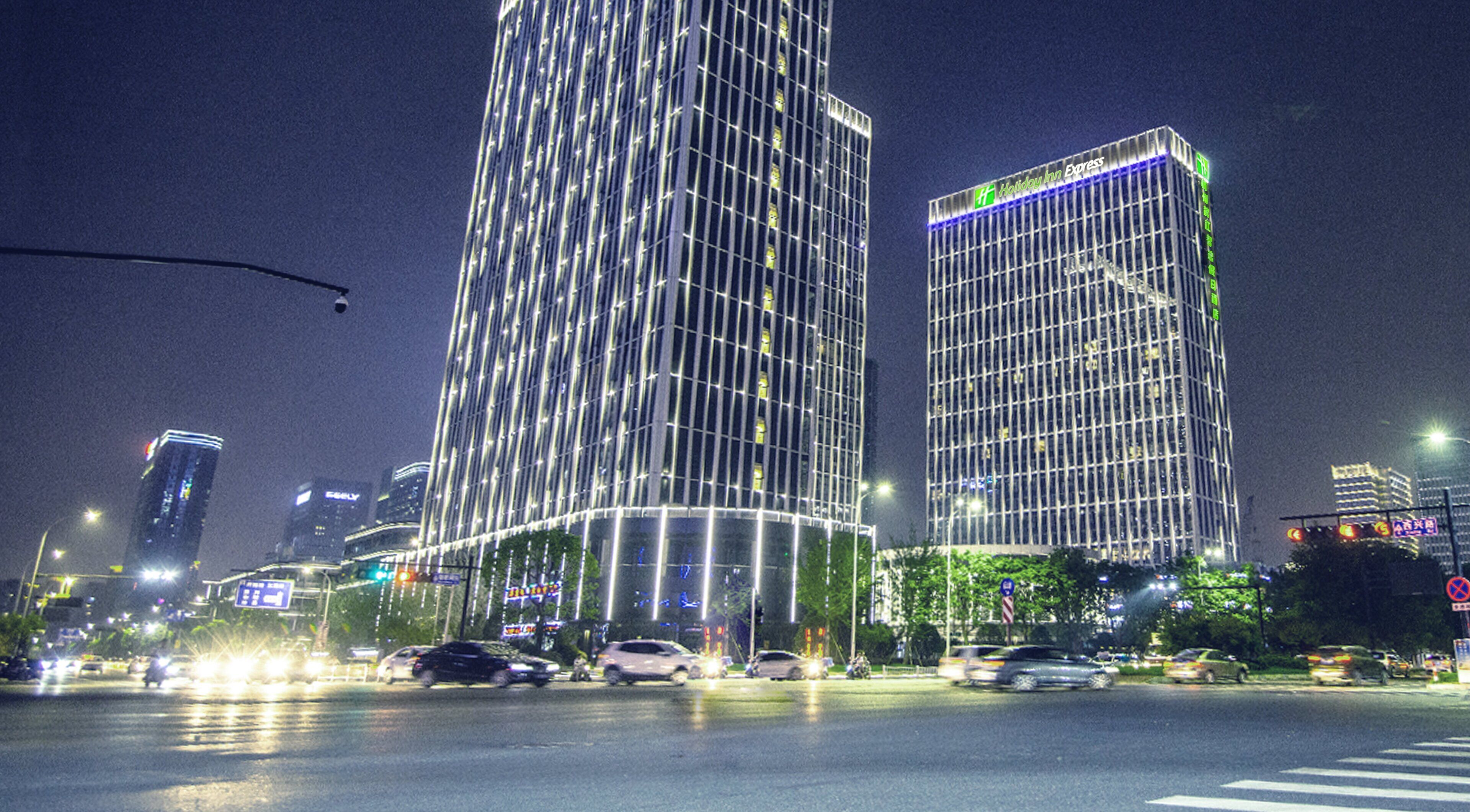 A high-rise building with a grid-like facade and illuminated windows at night.